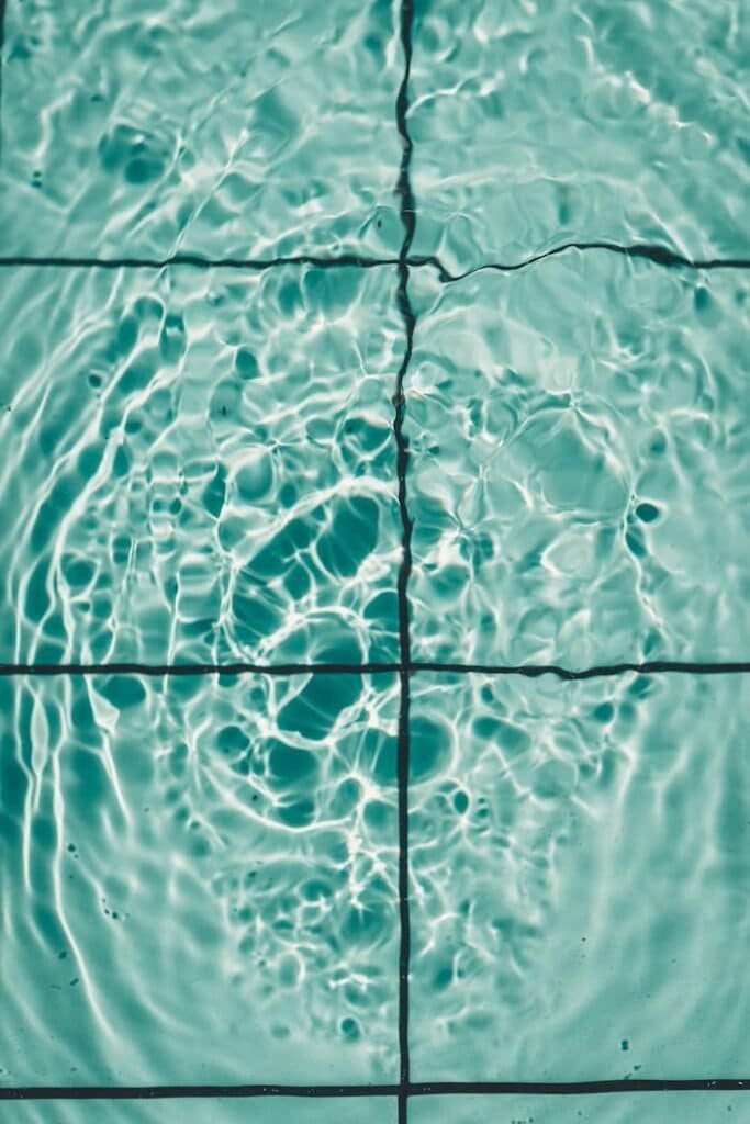 An overhead shot of rippling water captured through clear pool tiles, creating a calming pattern.