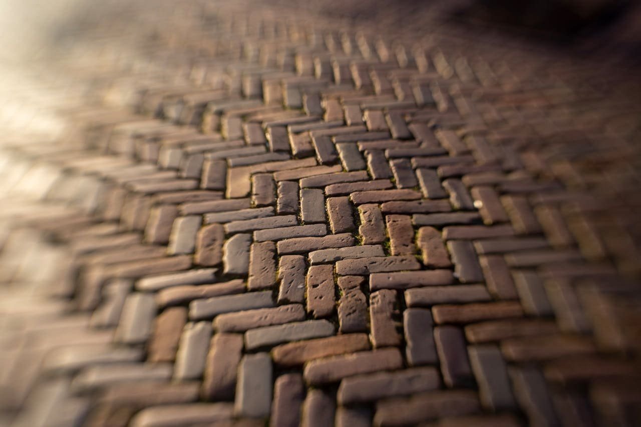 Intricate brick paving walkway, durable concrete pathway for outdoor surfaces, landscape design, high-quality construction, commercial and residential concrete paving.
