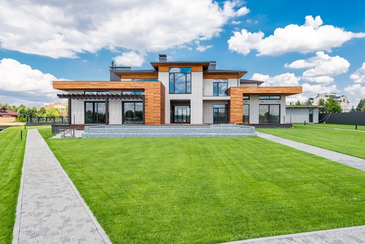 Modern residential home with concrete walkways and landscaping by Safepath Concrete, showcasing durable stamped concrete patios and smooth paver pathways for luxury outdoor living.